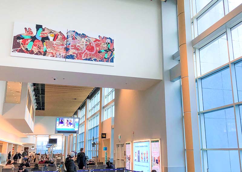 A photo of a painting hanging in the airport
